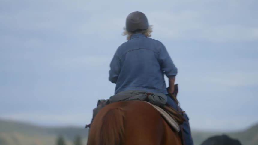A back clip of a lady riding a horse