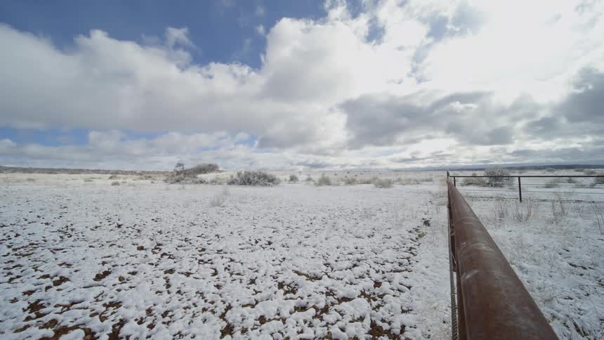 Farm with grass covered in snow on a cloudy day
