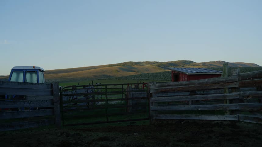 Wooden fence with houses in the background on a farm
