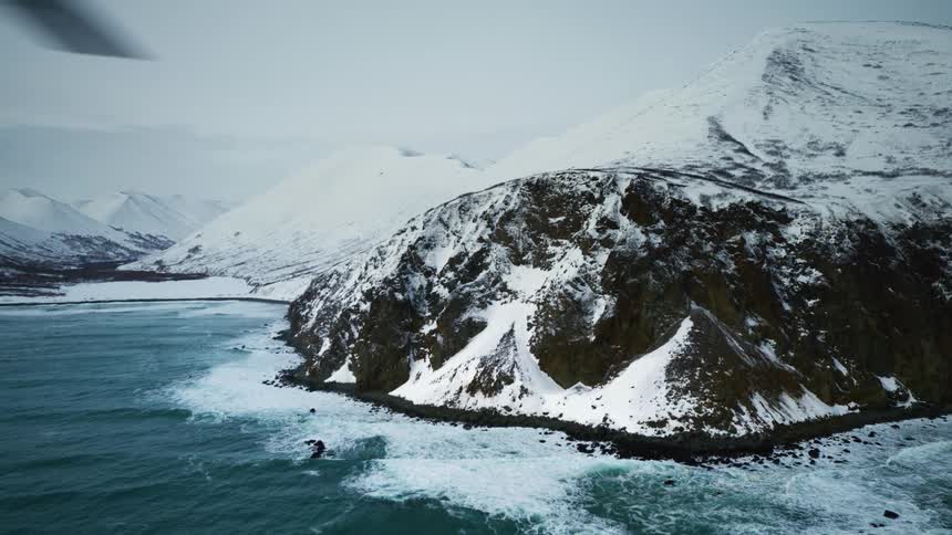 Aerial panorama of snowy mountains by the sea