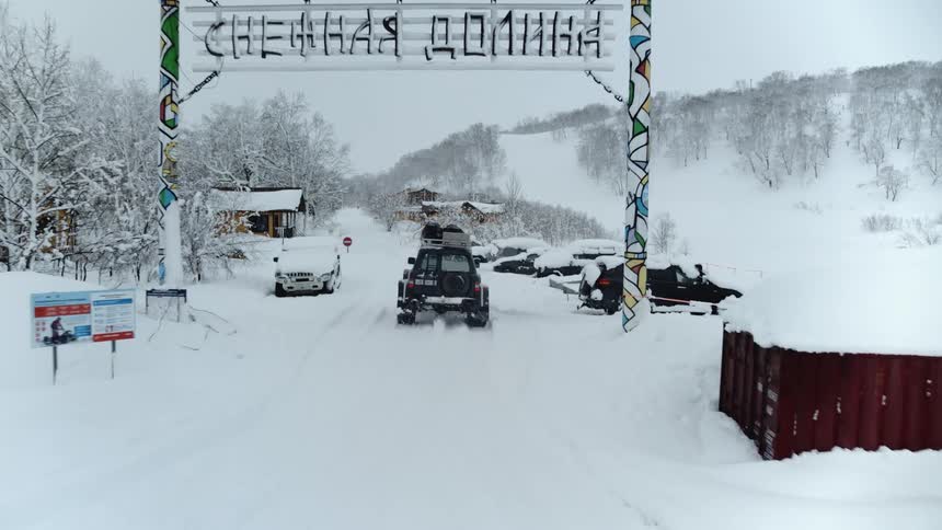 Car entering a parking lot in a snowcovered mountain valley