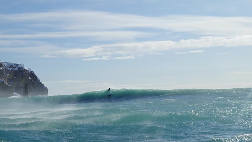 People riding waves in the sea with their surfboards