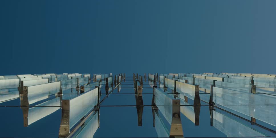 Reflective surface reflects transparent half walls and the blue sky
