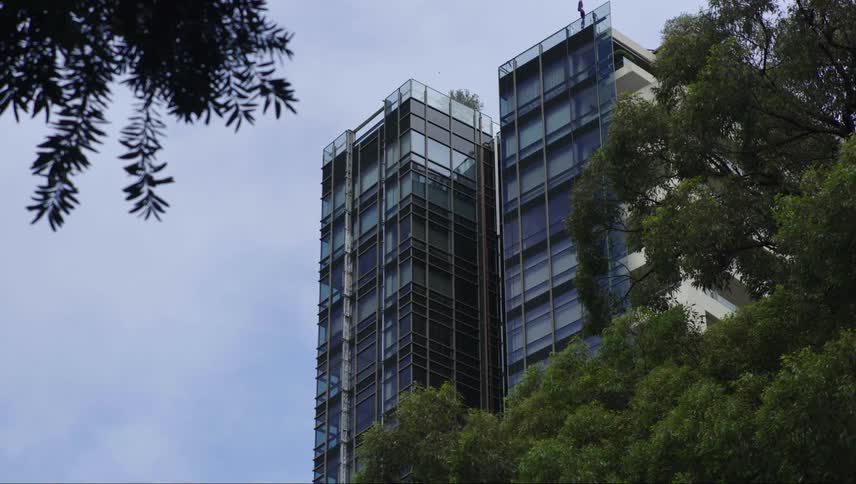 Two large modern buildings with trees in the foreground