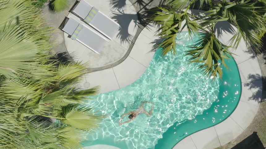 A woman is swimming in her pool