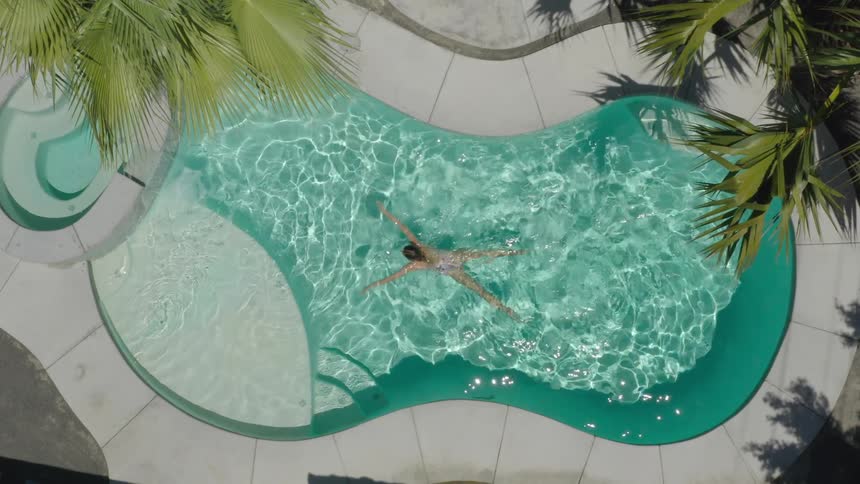 The woman swims across the pool