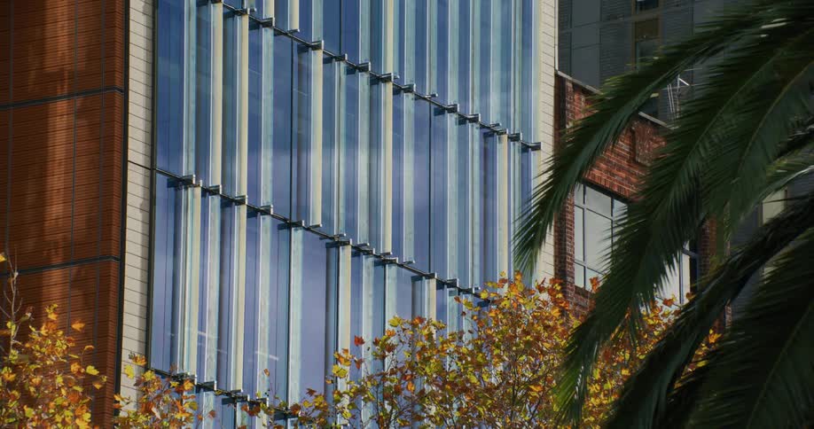 A closeup view of a modern buildings blue glass facade with visible vertical and horizontal metal supports