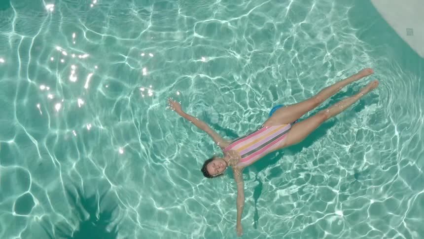 Woman in swimsuit lying in pool