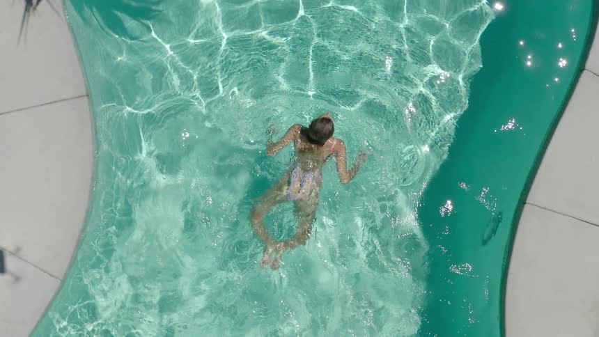 A woman swimming in a pool with rippling clear water