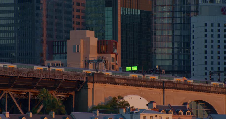 Two identical trains pass each other on an overpass while headed in opposite directions