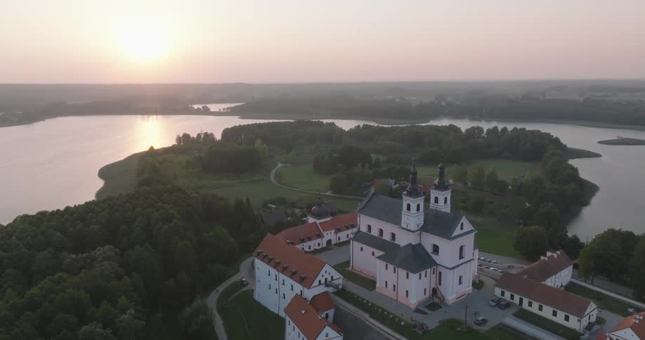A large church and associated structures sits near a river and islands