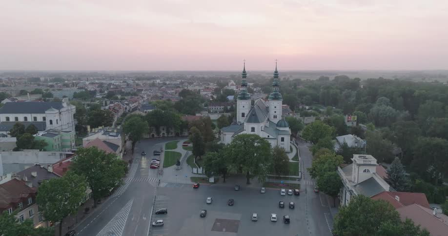 Aerial view of a town at dusk with prominent church spires and surrounding buildings