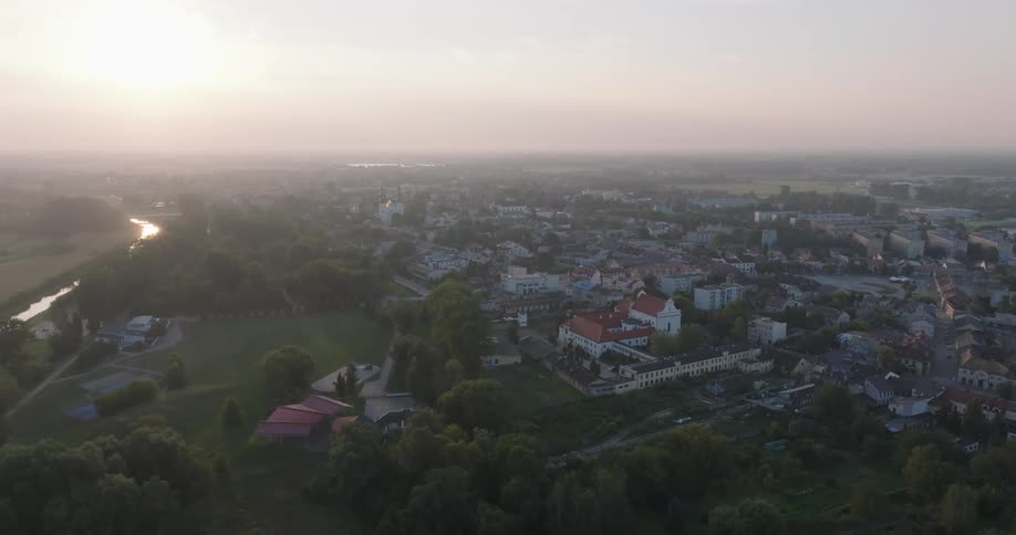 An aerial view of a town during twilight with a river curving through the landscape