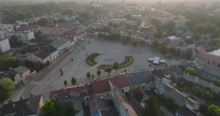 Aerial aerial panorama of a square in the center of an urban city with the reflection of the sun on the horizon