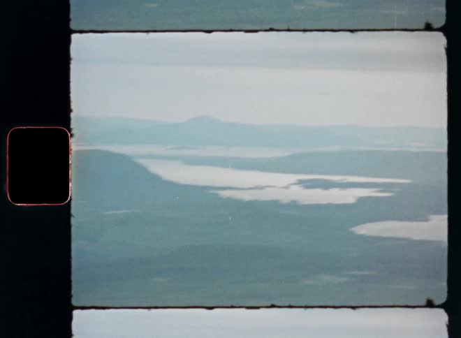 A mountain sits near a plain surrounded by bodies of water