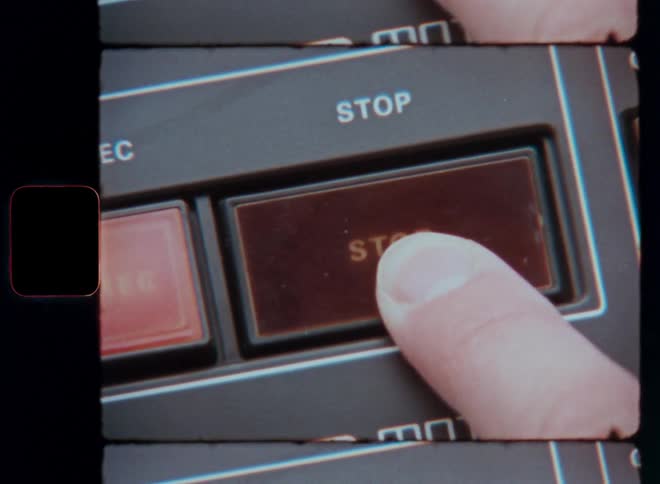 A person pushes a stop button on a machine with their finger