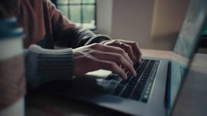 A man is typing on his laptop