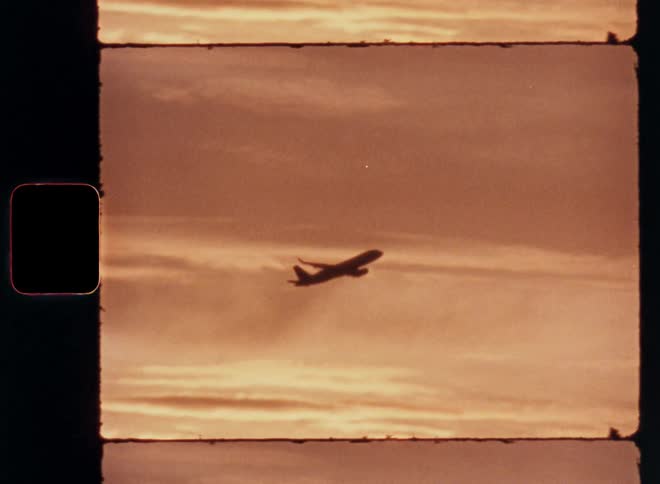 A commercial airplane climbs in the sky at dusk