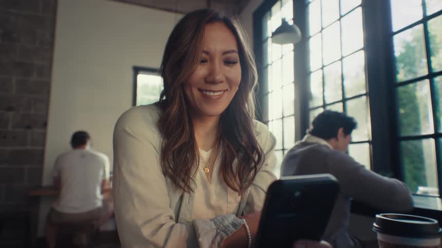 Woman sitting happily while interacting with her cellphone