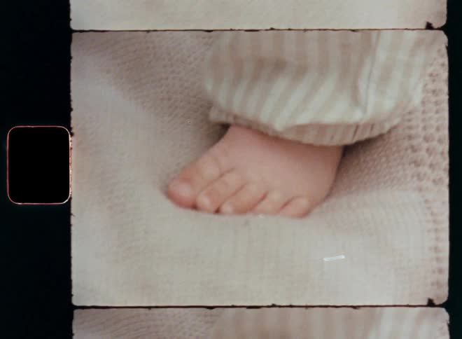 Close-up of the left foot of a small baby girl that is learning to stand up on her feet on a carpet or blanket struggling while balancing her body as symbol for early childhood development and learning how to walk as a toddler