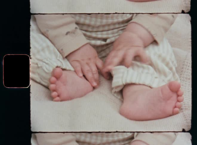 Close up of a toddler’s hands and feet with cute baby fat resting on top of a white or beige cloth while learning to sit up as part of growing up and early childhood development in relaxed atmosphere of a happy childhood