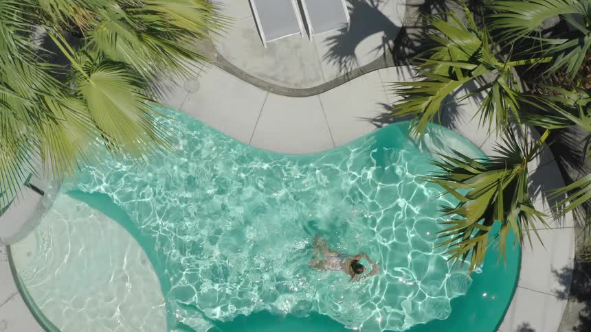 A woman swimming on a pool with rippling clear water
