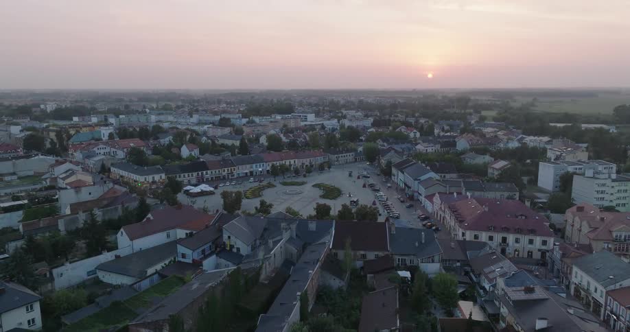 Panorama of an urban city with a square in the center and the sun rising on the horizon