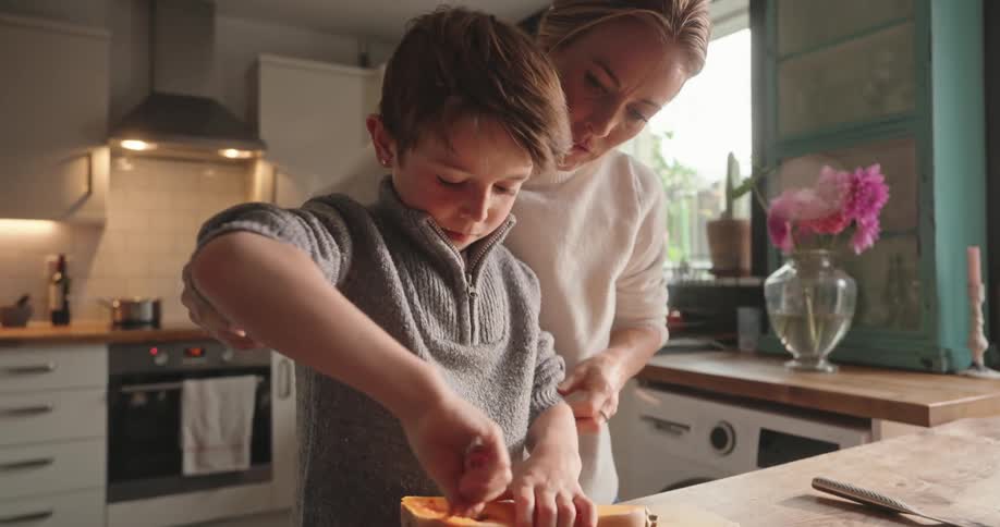 Mother helping her son remove the seeds from a papaya