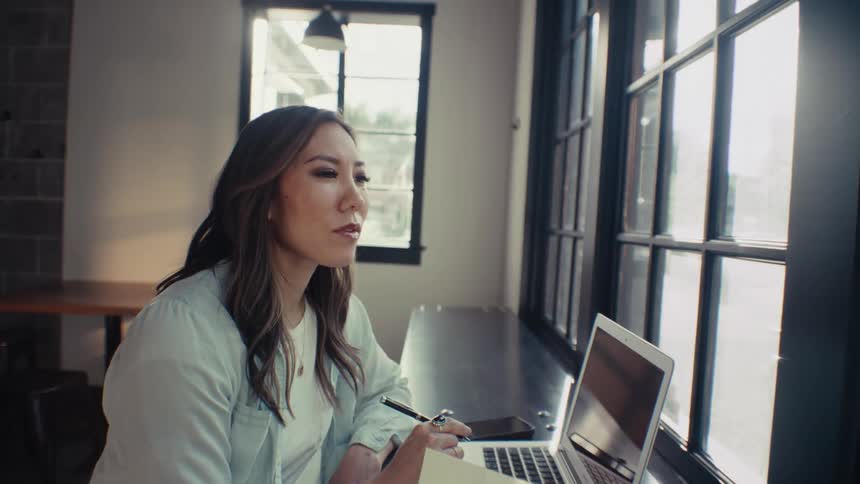 Woman sitting at an office desk looking thoughtful