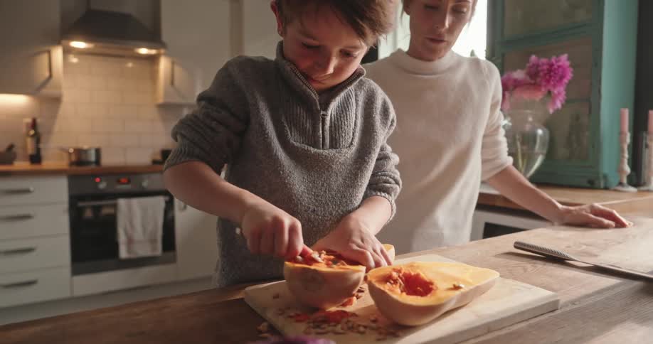 Mother and son prepare butternut squash in the kitchen