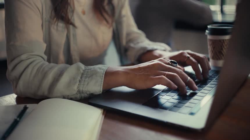 A close up clip of a lady typing on the laptop