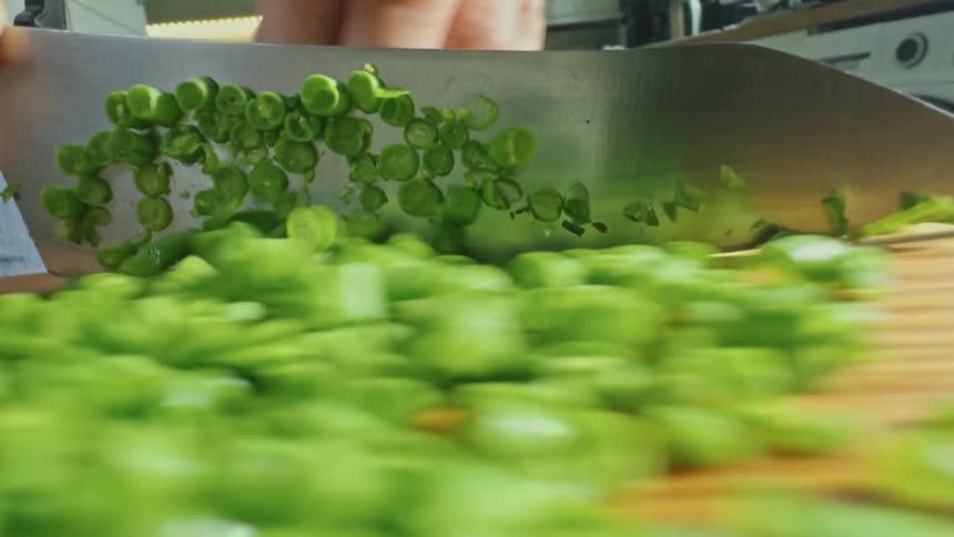 A cook is slicing up vegetables