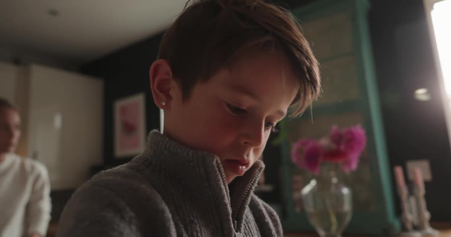 A boy is peeling carrots at home