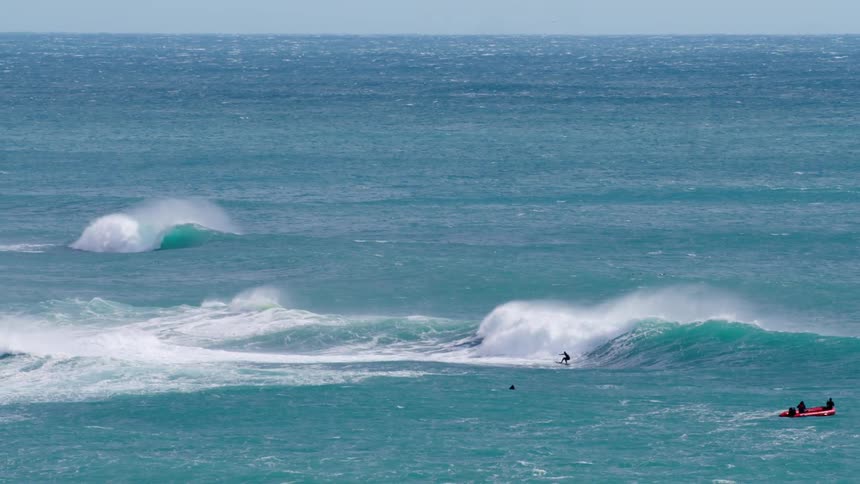 A man is surfing on a wave in the ocean