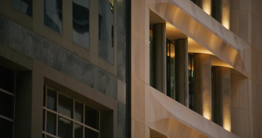 The exterior of a building is shown with windows lights and metal beams