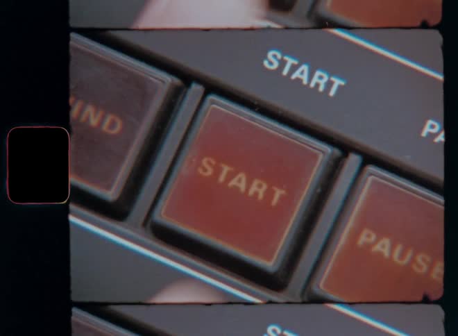 Close up of a finger pressing the start button on a vintage device captured on film