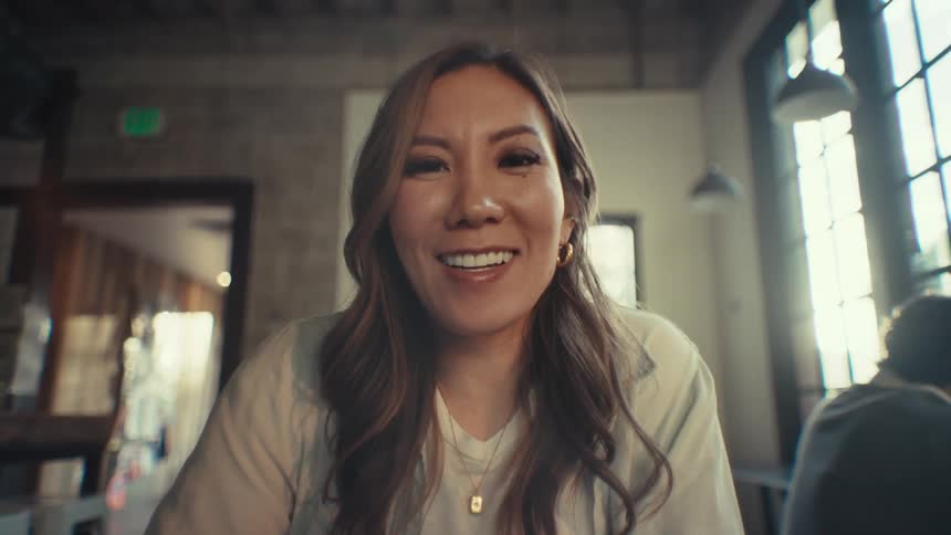 Portrait of a woman sitting down and talking happily at the camera
