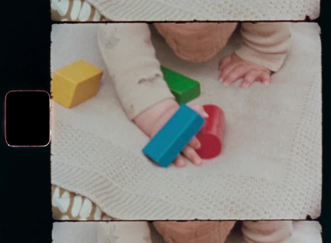 Curious and playful baby playing with colorful toy blocks in the colors green blue red and yellow while crawling or laying on a blanket outside as it tries to grab the toys with his small toddler hands enjoying the fun and leisure activity