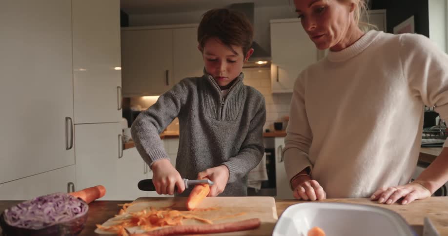 Mother and son cooking together in the kitchen at home