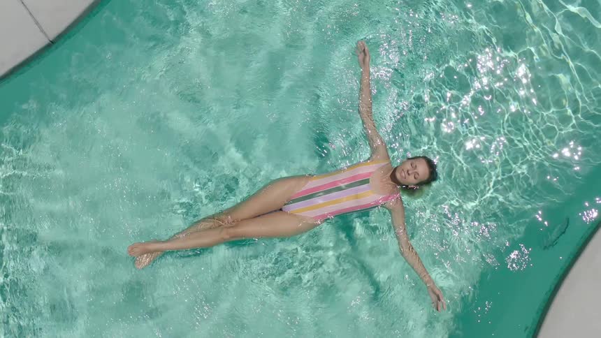 Woman lying floating in the pool relaxing
