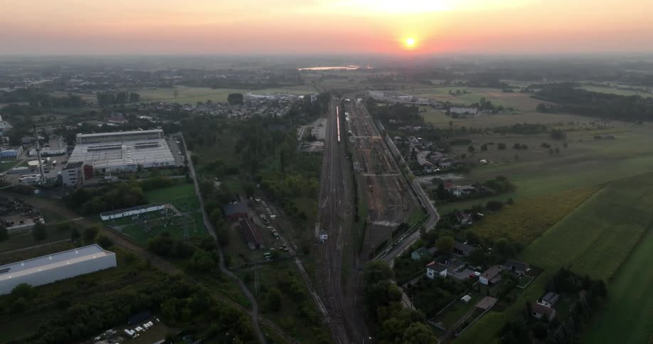Aerial panorama of an urban city and a rural area with an orange sun on the horizon