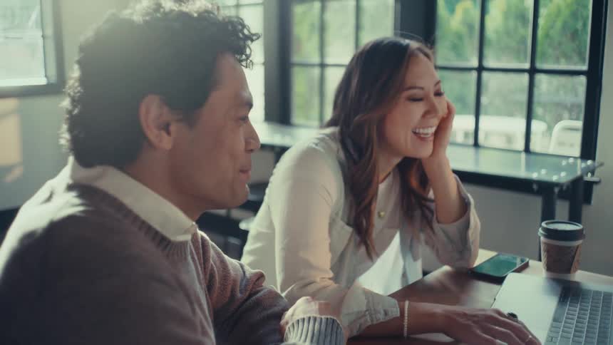 A man and woman discuss a business project while sitting in a cafe