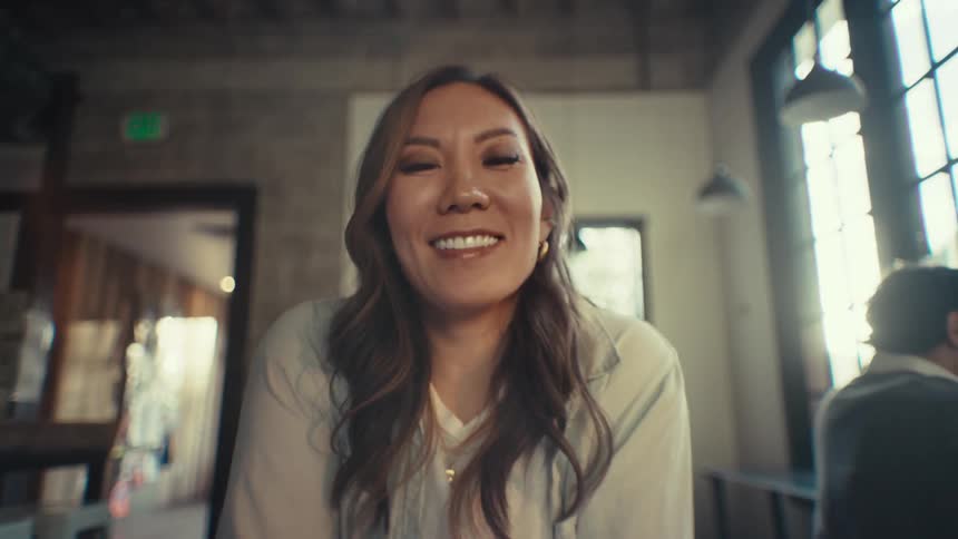 Closeup of a happy woman with long hair sitting in a coffee shop