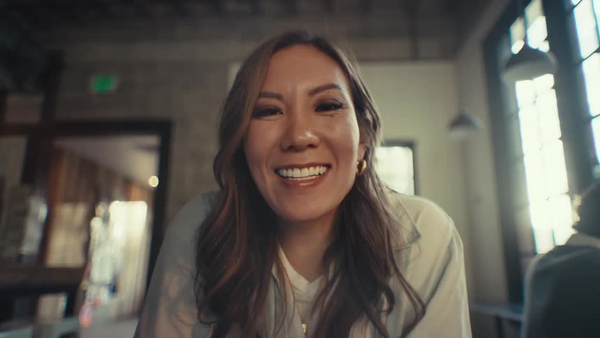 Woman indoors smiles and talks looking forward