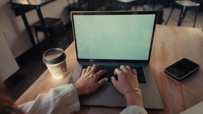 Womans hand typing on a laptop on the table