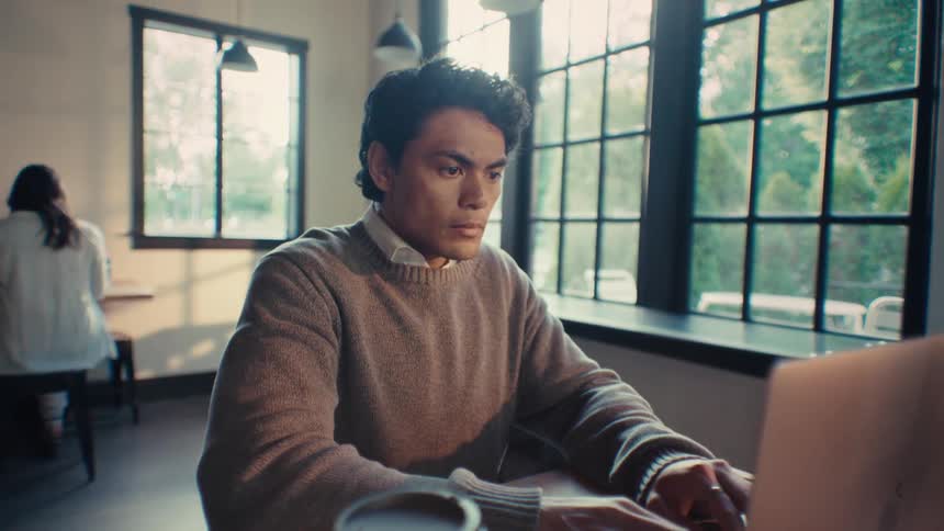 Concentrated man typing on laptop in an office room