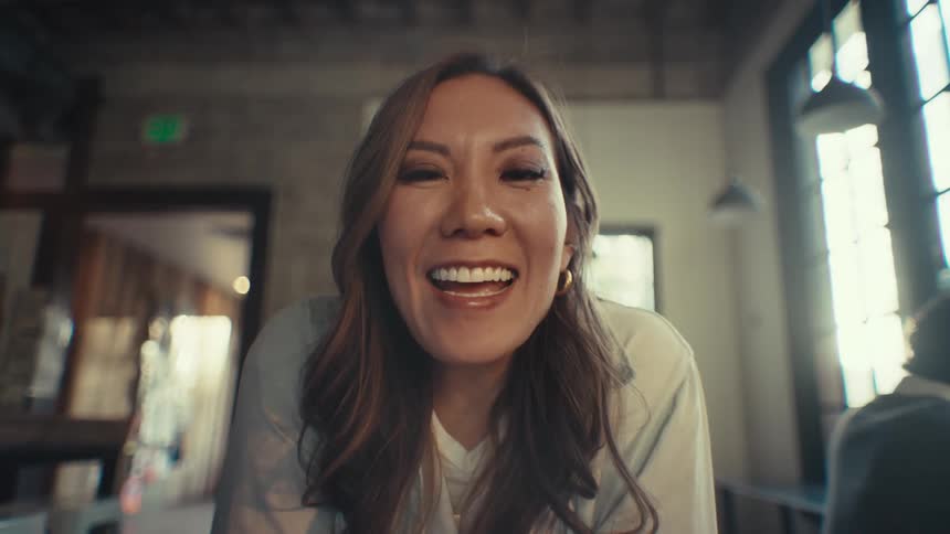 A female employee at work talks smiles and gives an air kiss