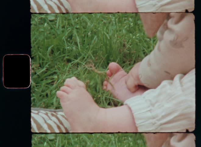 Baby sitting outside gathering or picking green grass grabbing it with the hands developing or experiencing sense of touch while interacting and connecting with Mother Nature as symbol for growing up or living in harmony with nature