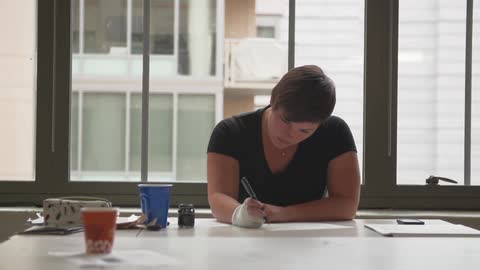 A person writing on a desk