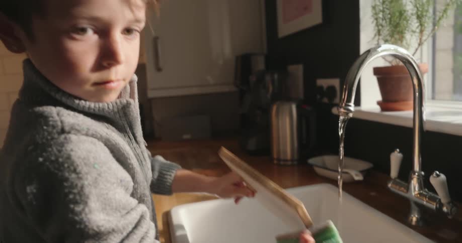Young at the kitchen sink washing a wood cutting board